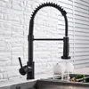 A black kitchen faucet with a pull-down sprayer is shown in use over a sink. Náhľad obrázku produktu