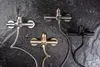 Three shower faucets with hoses are displayed against a dark, textured background. Produktbild-Vorschau