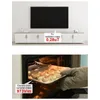 A split image showing a TV and TV stand in the top half, and a person putting a tray of food into an electric oven in the bottom half. Náhled obrázku produktu