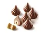 A group of chocolate candies with hazelnuts, with one candy cut in half to show the filling. Produktbild-Vorschau