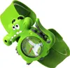 A close-up studio shot of a green cartoon crocodile watch for children. Voir les images du produit