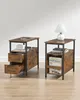Two rustic-style side tables with drawers and shelves are displayed on a light wooden floor. Náhled obrázku produktu