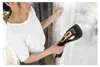 A woman is using a handheld steamer on a curtain. Podgląd zdjęcia produktu