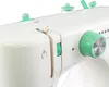 A close-up view of the top section of a white sewing machine with green accents. Produktbild-Vorschau