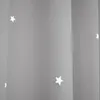 A close-up view of a gray curtain with white star cutouts. Produktbild-Vorschau