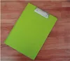 A bright green clipboard lies on a wooden surface. Produktbild-Vorschau