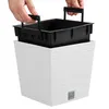 Hands holding a black planter insert over a white planter pot. Náhľad obrázku produktu