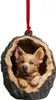 A dog ornament inside a hollowed-out log, hanging from a red ribbon. Produktbild-Vorschau