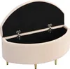 An open storage ottoman with a beige velvet exterior and a black interior, resting on gold metal legs. Produktbild-Vorschau