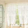 A bright room with white curtains patterned with light gray squares, a green door, and a chair. Produktbild-Vorschau