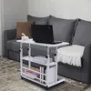 A white adjustable side table with a laptop and books is placed next to a gray sofa. Náhled obrázku produktu