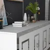A close-up view of a white sideboard with silver accents, featuring decorative books and decorative items on top. Anteprima dell’immagine prodotto