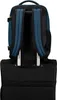 The back of a blue and black backpack is shown attached to the handle of a black rolling suitcase. Produktbild-Vorschau