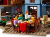 A LEGO® scene depicting a family gathered around a dining table, with a Christmas tree and decorations in the background. Podgląd zdjęcia produktu