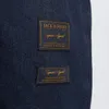 A close-up view of two labels on a dark blue fabric. Produktbild-Vorschau
