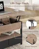 A close-up view of a lift-top coffee table with its top raised, revealing storage compartments. Inset circles highlight the lifting mechanism and a finger grip. Voir les images du produit