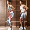 A man and a woman are exercising with resistance bands in a gym. Náhľad obrázku produktu