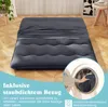 A dark gray futon mattress laid out on a wooden floor, with a portion of a washing machine visible in a circular overlay. Náhled obrázku produktu
