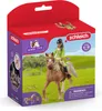 A Schleich Horse Club toy set featuring a girl riding a horse, presented in its retail packaging against a grassy field background. Produktbild-Vorschau