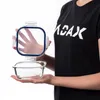 A person is holding an open glass food storage container. Anteprima dell’immagine prodotto