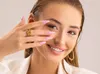 Close-up of a woman's face and hand, showing her nails and jewelry. Náhled obrázku produktu