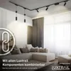 A living room with a sectional sofa and a track lighting system installed on the ceiling. Produktbild-Vorschau