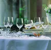 A table setting with wine glasses and plates. Produktbild-Vorschau