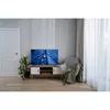 A living room scene with a TV on a stand, a chair with a blanket, and a door. Produktbild-Vorschau