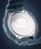Close-up of the back of a teal Casio G-Shock watch, showing the metal case back with engraved text and a serial number sticker. Produktbild-Vorschau