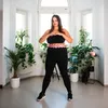 A woman is hula-hooping in a bright room with plants. Podgląd zdjęcia produktu