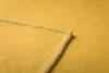 A close-up view of a yellow blanket showing the stitching detail on the corner. Produktbild-Vorschau