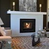 A living room scene featuring a fireplace with a fire burning inside, a mantelpiece with decorations, and a coffee table with vases. Produktbild-Vorschau