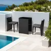 A black rattan bar set with two chairs and a table is placed on a patio next to a swimming pool, with lush greenery and the ocean in the background. Náhled obrázku produktu