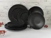 A stack of black plates and a single plate on a stand, set against a white brick wall. Náhľad obrázku produktu