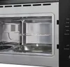 Interior view of a built-in microwave oven, showing the turntable, rack, and interior walls. Produktbild-Vorschau