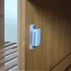 A close-up shot of a magnetic catch on a wooden cabinet door. Podgląd zdjęcia produktu
