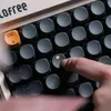 A close-up shot of a person's finger pressing the 'W' key on a retro-style mechanical keyboard. Produktbild-Vorschau