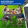 A family is having a picnic or barbecue outdoors at a table with benches. Produktbild-Vorschau