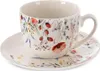 A white porcelain teacup and saucer with a floral pattern. Voir les images du produit