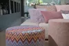A living room setting with a sofa and decorative pillows, featuring two poufs in the foreground. Produktbild-Vorschau