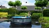 Two people are playing in a round swimming pool in a backyard. Náhled obrázku produktu