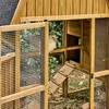 A chicken coop with a chicken inside, viewed through an open door. Anteprima dell’immagine prodotto