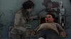 A woman is tending to a man who is sitting in a medical chair. Produktbild-Vorschau