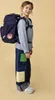 A young girl wearing a backpack and jeans, posing for a product shot. Produktbild-Vorschau