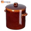 A brown ceramic pot with a lid and handles, on a white background. Voir les images du produit