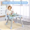A young boy sits at a child's table and chair set, with toys and books on the table. Podgląd zdjęcia produktu