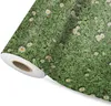 A roll of wallpaper with a daisy pattern on a white background. Produktbild-Vorschau