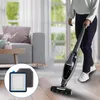 A person is using a vacuum cleaner in a living room, with a close-up of vacuum cleaner filters in the foreground. Produktbild-Vorschau