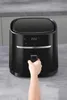 A hand is shown pulling the drawer of a black air fryer. Produktbild-Vorschau