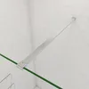 A shower screen support bar and a green edge of a shower screen against a tiled wall. Produktbild-Vorschau